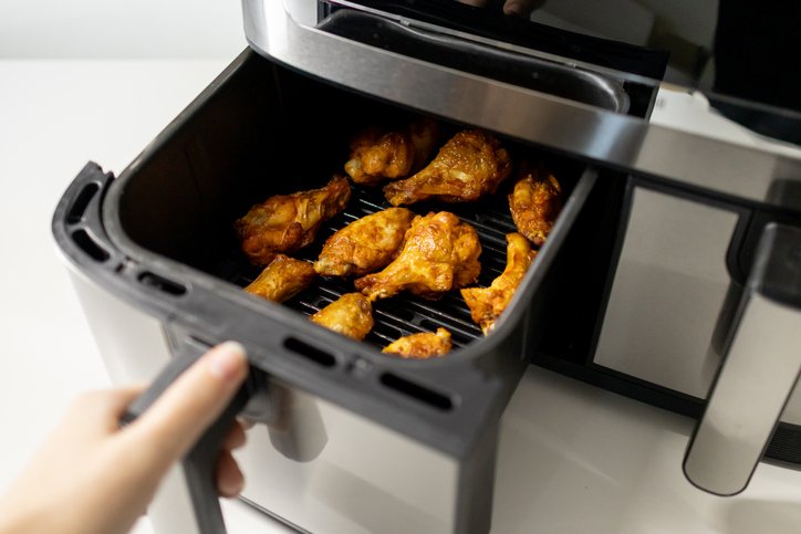 Alitas de pollo en freidora de aire doradas en la cesta