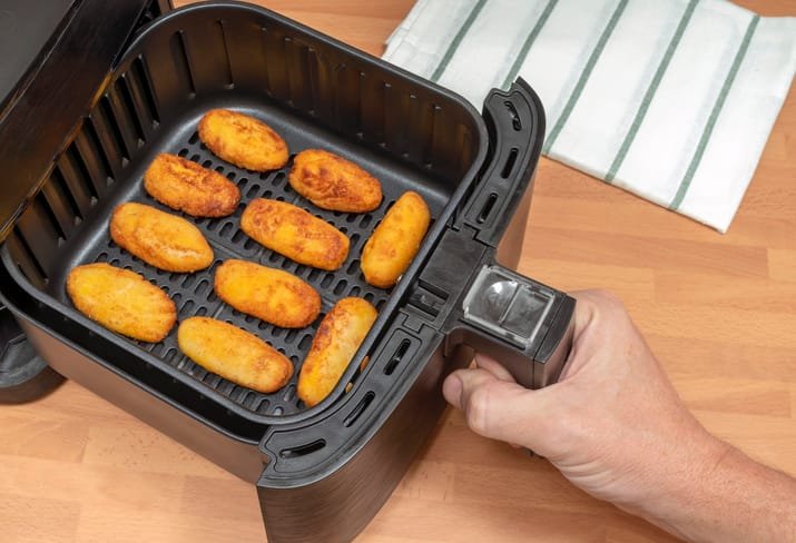 Croquetas de jamón en freidora de aire doradas en la cesta