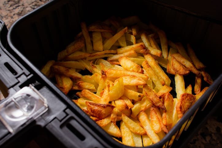 Patatas fritas en freidora de aire recién hechas en la cesta